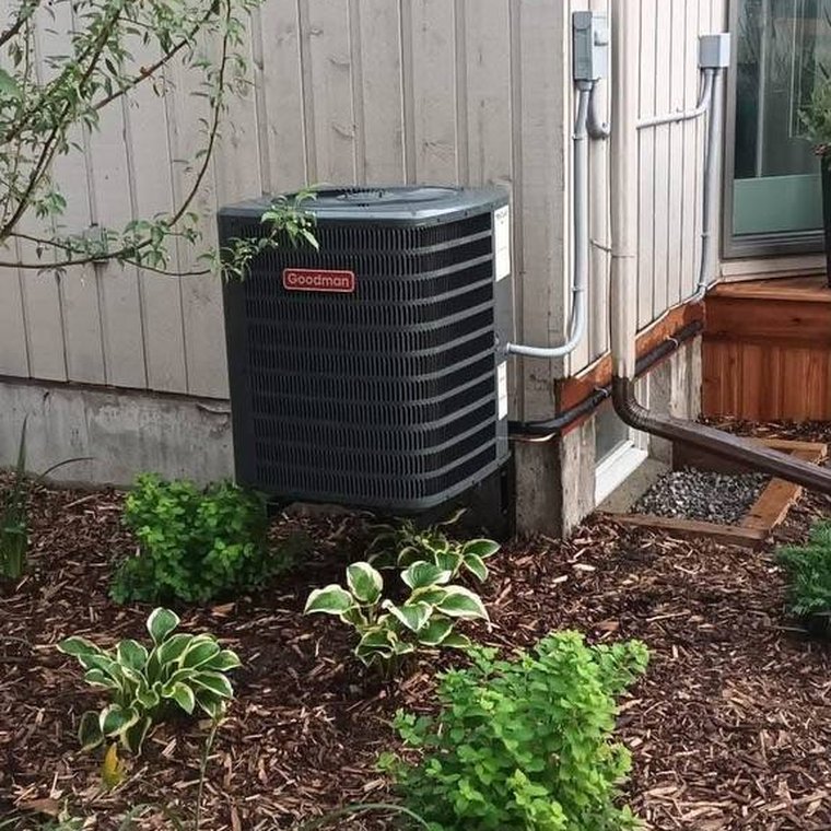 An outdoor air conditioning unit installed beside a house