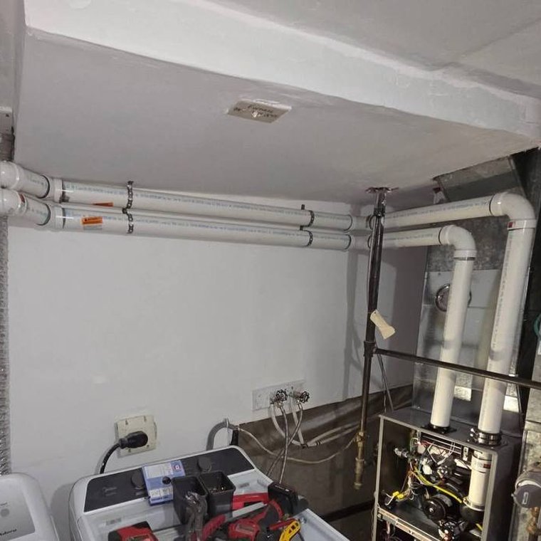 Vent and duct runs across the ceiling of a mechanical room